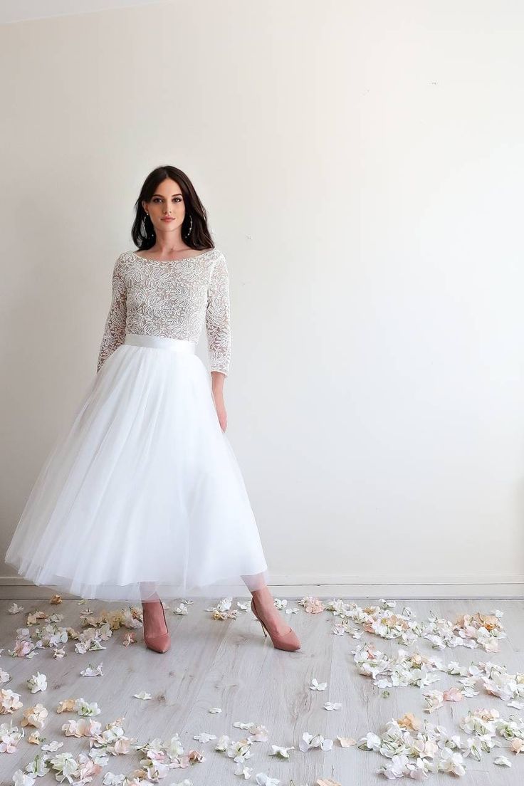 a woman in a white dress is standing on the floor with flowers all around her