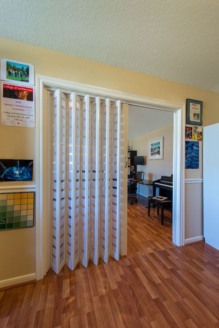 a living room with hard wood floors and sliding doors