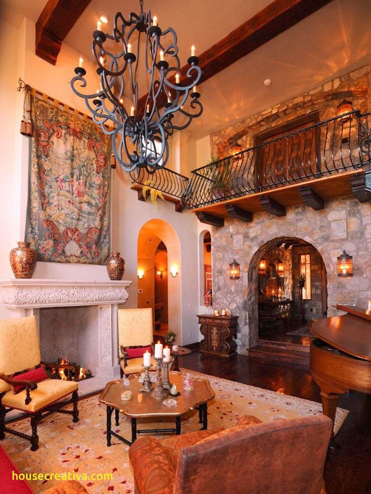 a living room filled with furniture and a chandelier hanging from the ceiling over a fire place