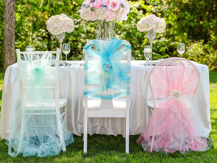 the table is set up with chairs and tables covered in tulle for an elegant wedding