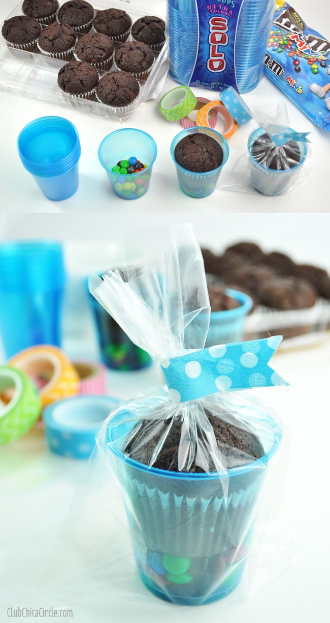 chocolate cupcakes and cookies in plastic cups with candy wrappers on the side