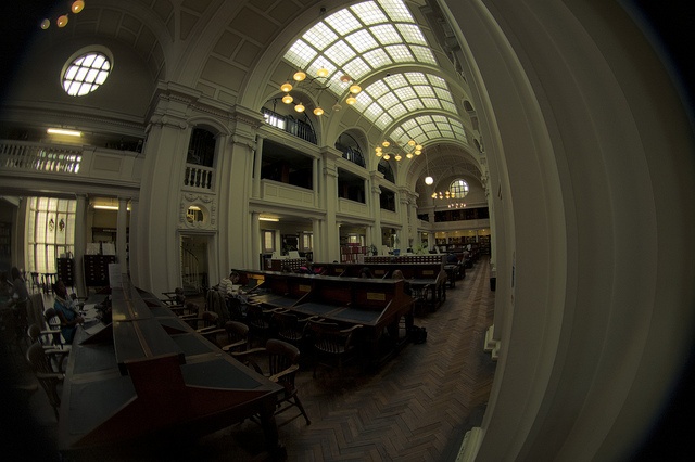 the inside of a building with many tables and chairs in it's center area