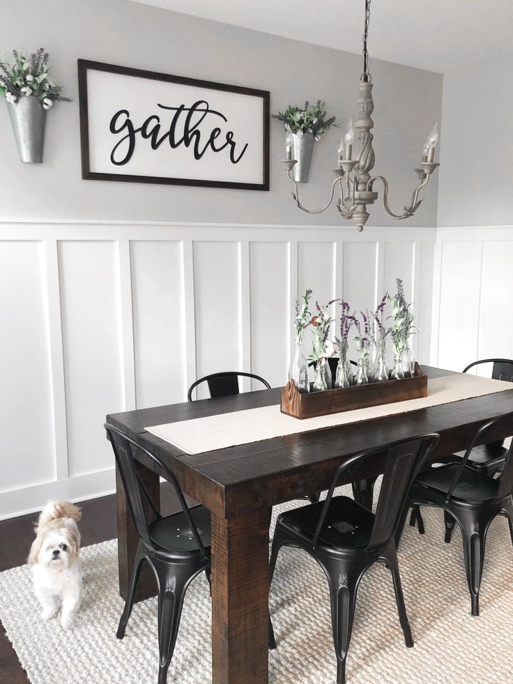 a dining room table with black chairs and a white rug