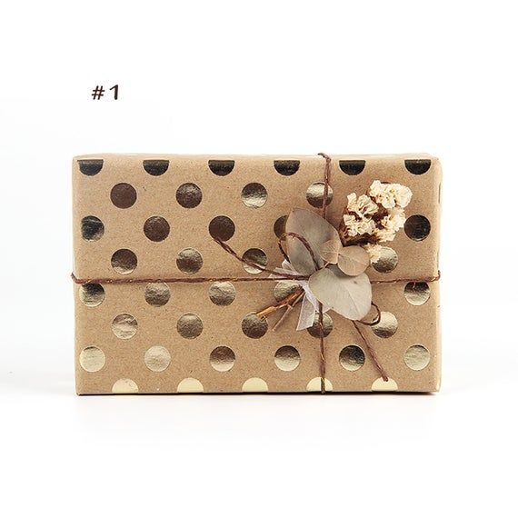 a gift wrapped in brown polka dot paper with a flower on it's side