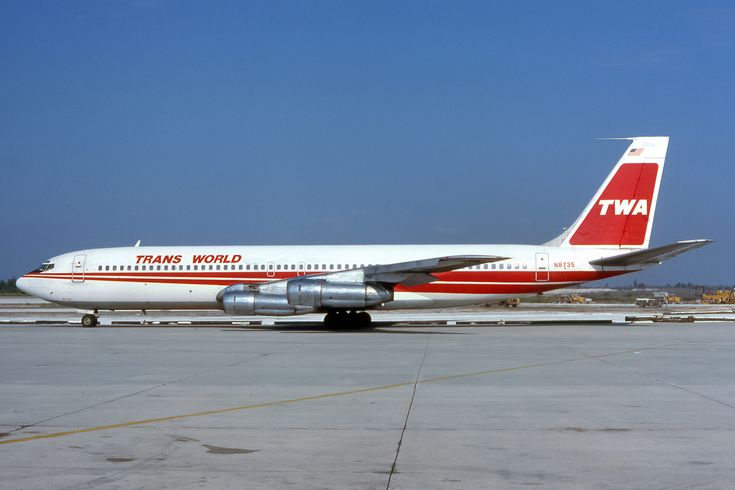 a red and white plane is on the tarmac at an air port run way