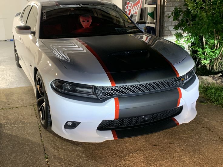 a white and orange car parked in front of a building