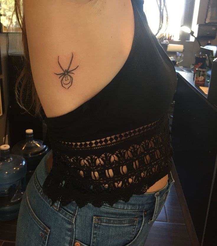 a woman with a spider tattoo on her back