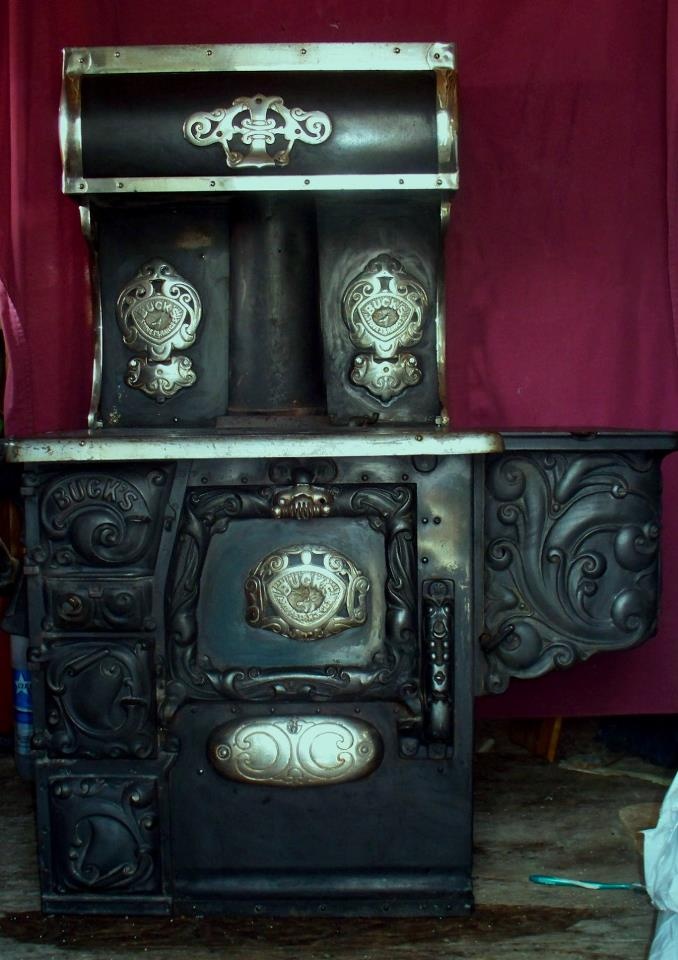 an old fashioned stove in front of a red curtain