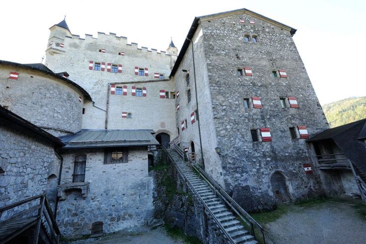 an old castle with stairs leading up to the second floor and another building in the background