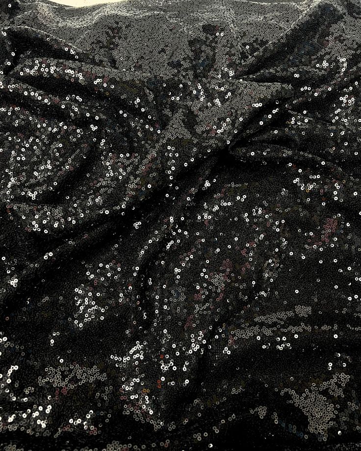 black and silver sequins fabric with white dots on the top, closeup