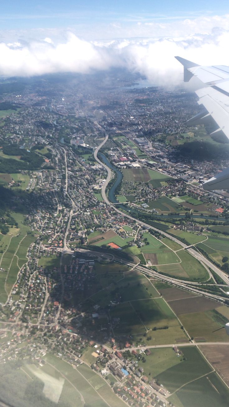 an airplane wing flying over a city and river