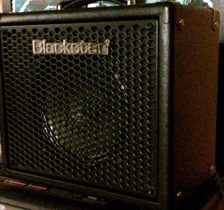 a black guitar amplifier sitting on top of a table