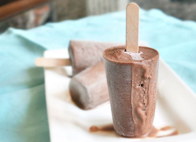 an ice cream sundae on a plate with a wooden stick sticking out of it