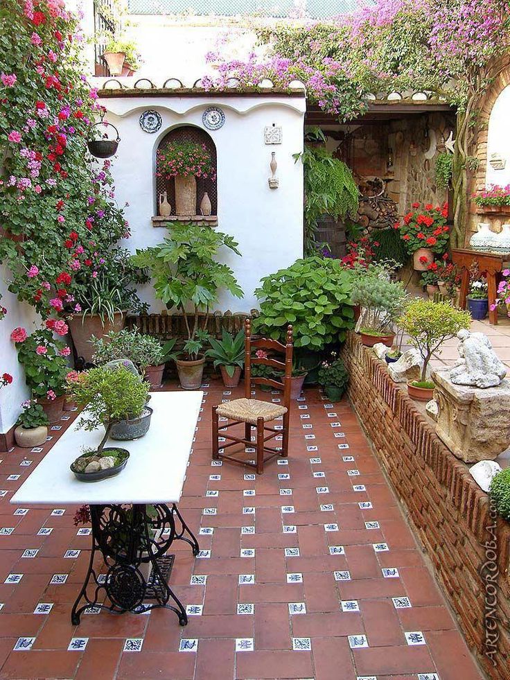 an outdoor dining area with potted plants and flowers