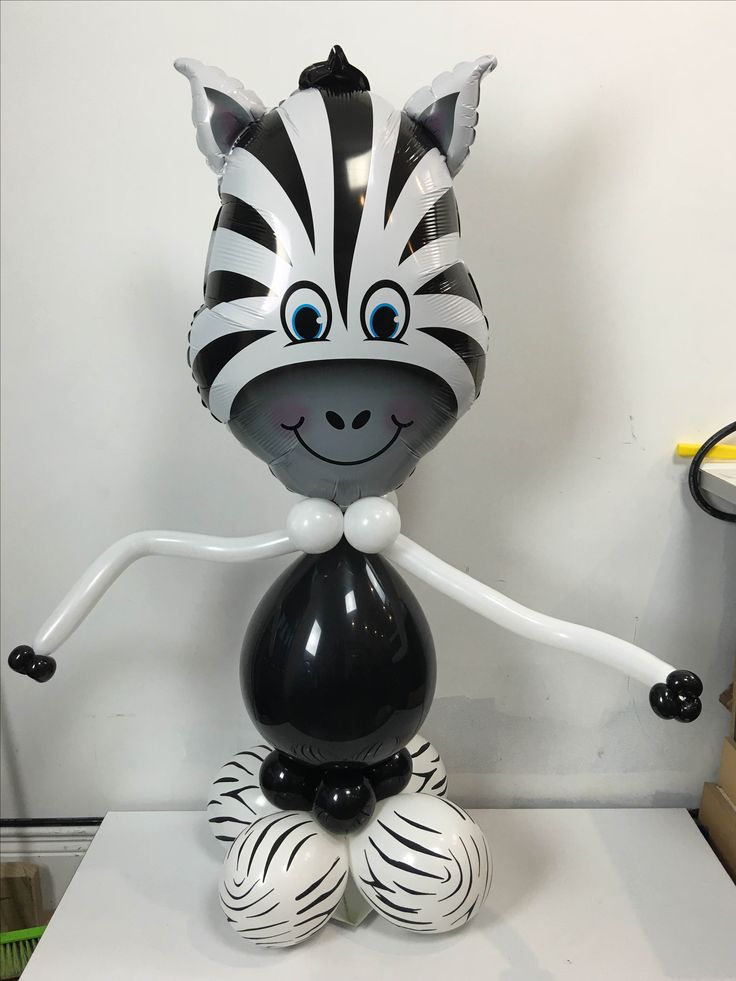 a zebra balloon sitting on top of a white table next to a black and white object