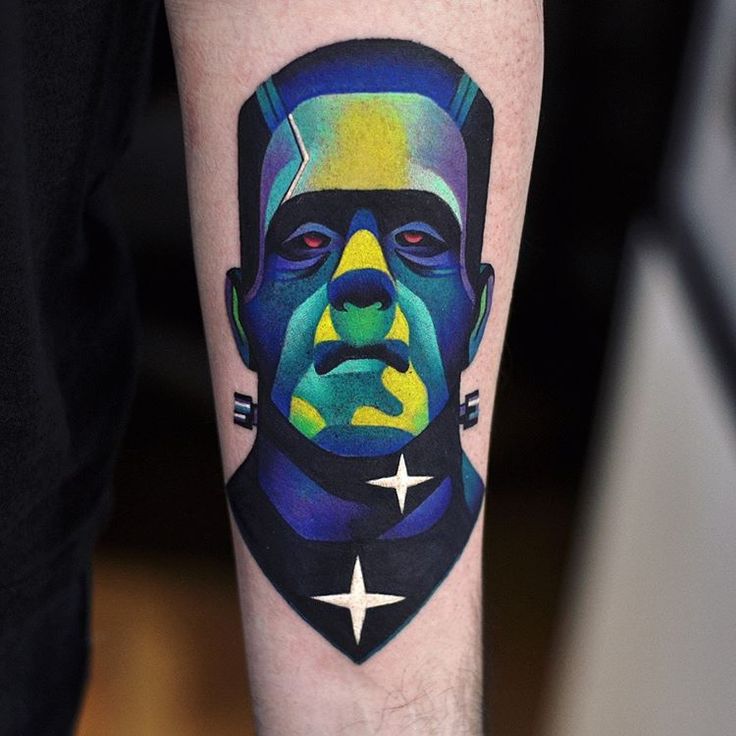 a man's leg with a colorful portrait tattoo on the left side of his arm