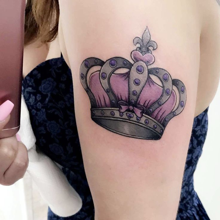 a woman's arm with a crown tattoo on the left side of her body