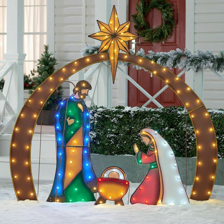 a lighted nativity scene in front of a house