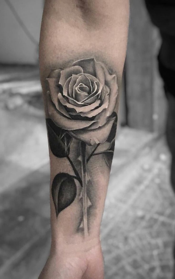 a black and white rose tattoo on the arm