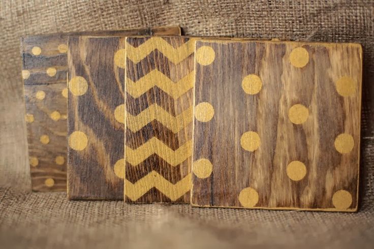 three pieces of wood with gold polka dots on them are sitting on a brown couch