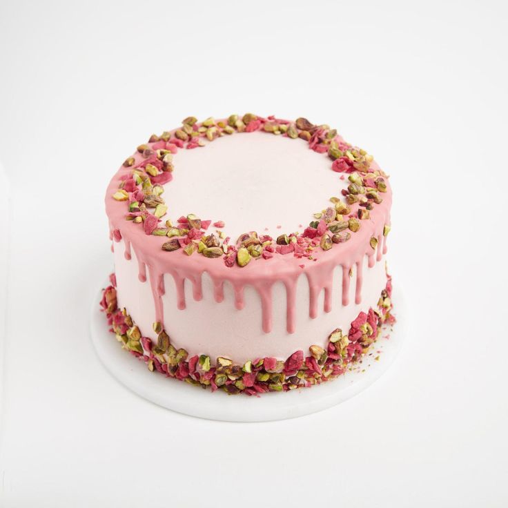 a white cake with pink icing and sprinkles