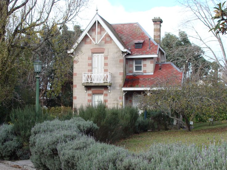 an old brick house surrounded by bushes and trees