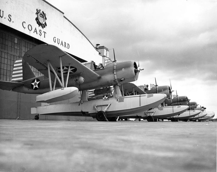 an old black and white photo of airplanes parked in front of a building with the u s coast guard written on it