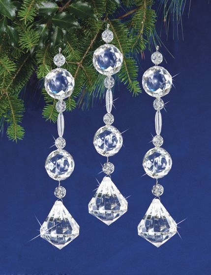 three crystal ornaments hanging from a christmas tree