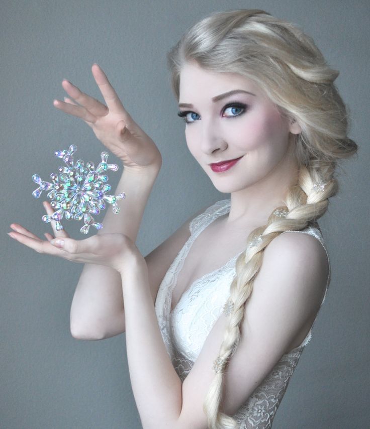 a woman in white dress holding up a snowflake