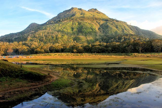 the mountains are reflected in the still water on the river bank as ...