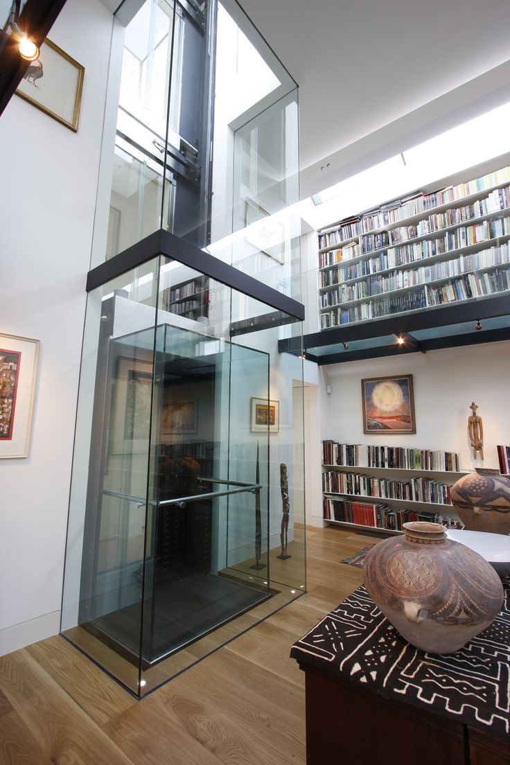 the inside of a room with bookshelves and a glass case in front of it