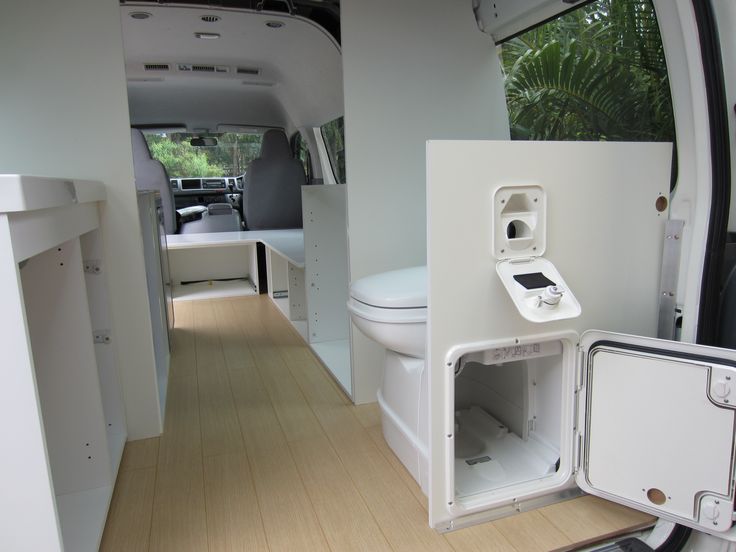 an interior view of a camper van with the door open and toilet in it