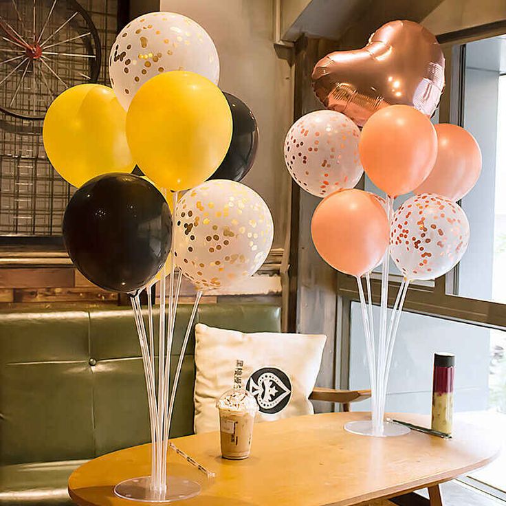 there are many balloons in the vases on the table, and one is yellow