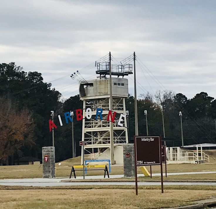 a large tower with the word atlanta on it in front of a field and trees