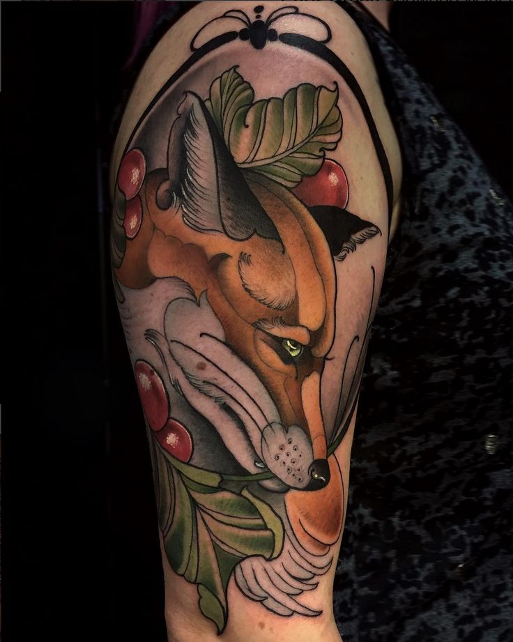 a close up of a person's arm with a tattoo on it and a fox