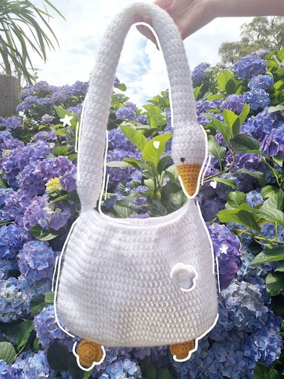 a white purse with an ice cream cone sticking out of it's center surrounded by blue flowers