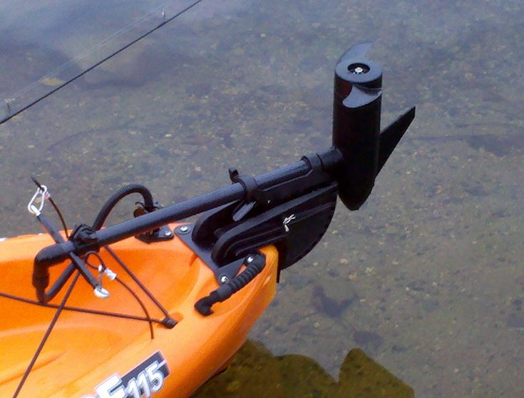 an orange kayak in the water with a fishing pole attached to it