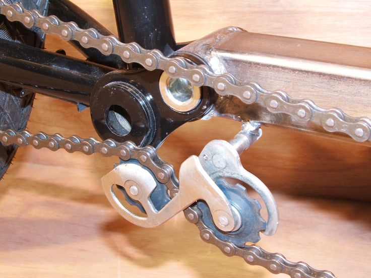 a close up of a bike chain on a wooden table