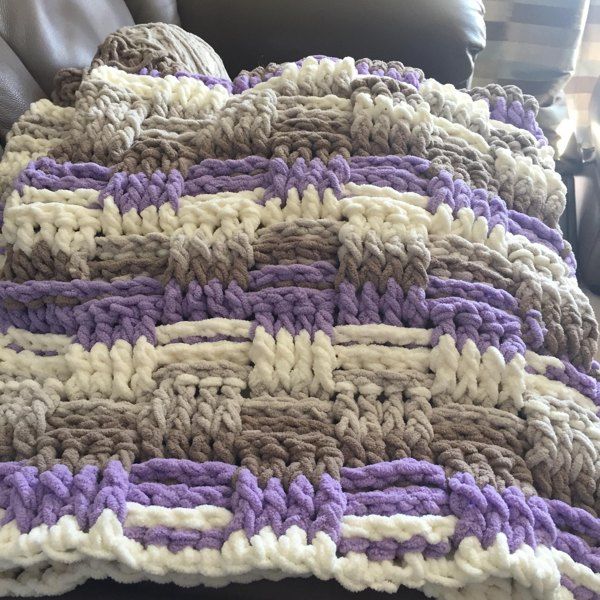 a crocheted blanket sitting on top of a couch