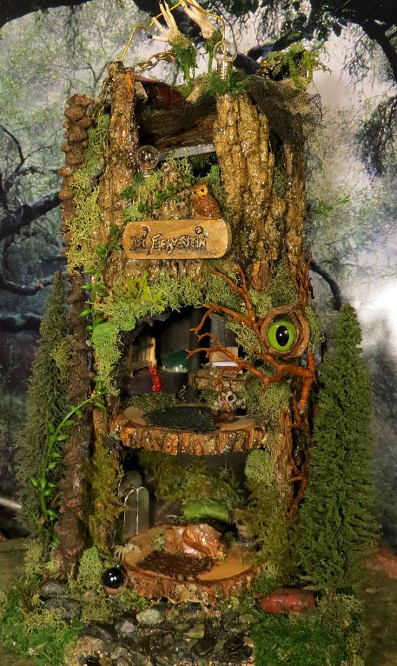 a fake tree house with moss growing on it's sides and an evil eye at the top