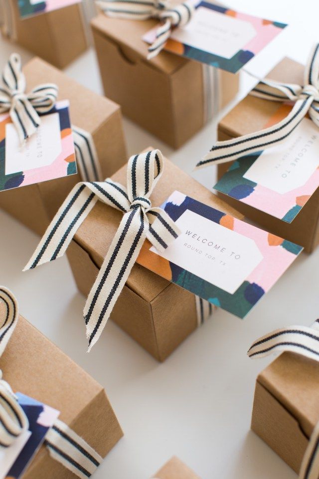 small brown boxes with black and white ribbons tied around them, each box has a name tag on it