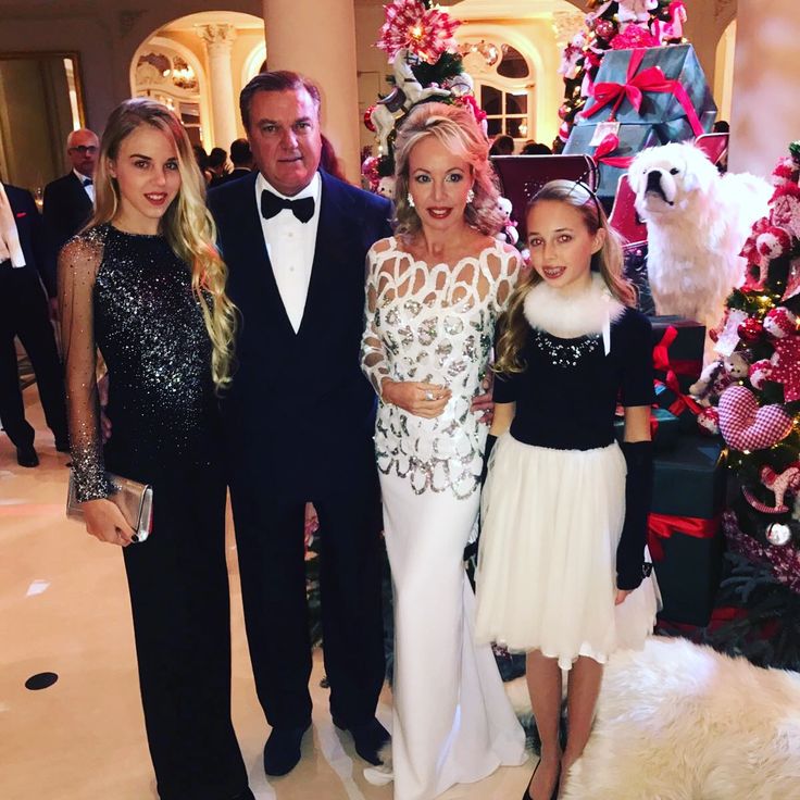 three women and two men standing in front of a christmas tree