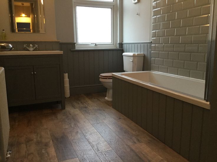 a bathroom with wood floors and gray walls