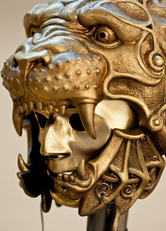 a golden lion head sculpture on a black metal pole with an intricately detailed design