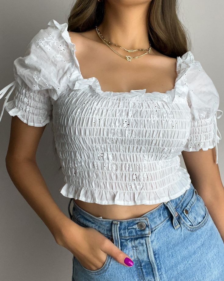 The Lana Crop Top is the perfect blend of comfort and style. Made from 100% cotton, this smocked top features puff sleeves for a playful touch. Its cropped design hugs your figure, offering a flattering fit that pairs perfectly with high-waisted jeans, skirts, or shorts. A versatile piece that works for both casual and dressed-up occasions! Key Features: Fit: True to size for most, with a cropped, flattering fit. Stretch: Some stretch from the smocked design for comfort. Material: 100% Cotton fo Smocked Crop Top, White Ruffled Top, Fitted Smocked Top For Summer, Fitted Tops With Smocked Back For Day Out, Fitted Tops With Smocked Bodice For Day Out, Fitted Top With Smocked Bodice For Day Out, Fitted Smocked Back Top For Day Out, Fitted Smocked Bodice Top For Day Out, Trendy Fitted Smocked Top