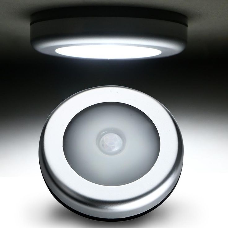 a white light that is on top of a ceiling fixture in a dark room with dim lighting