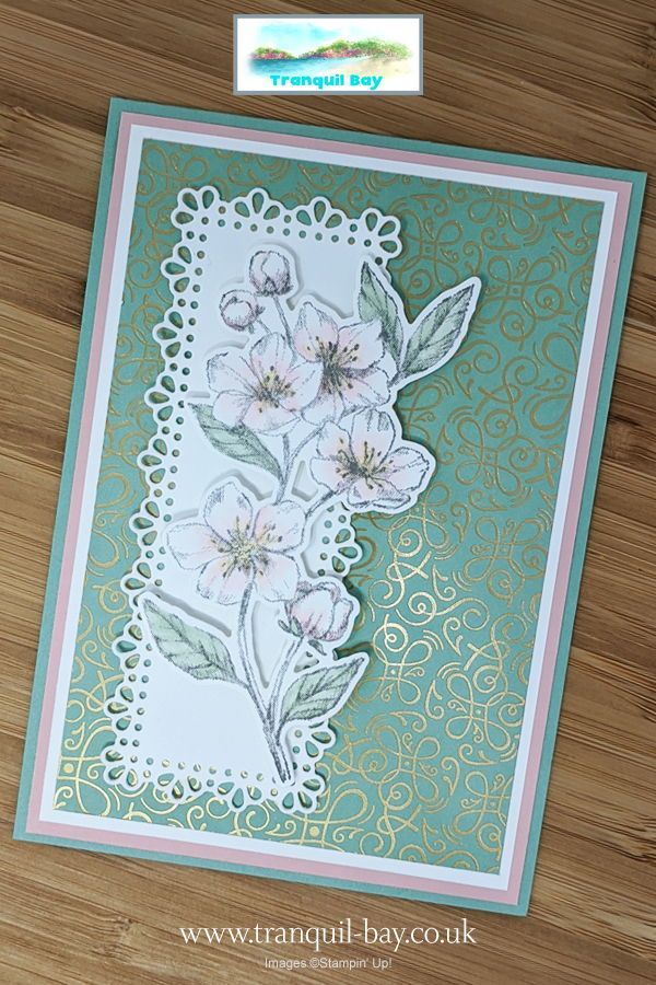 a card with flowers on it sitting on top of a wooden table next to a piece of paper