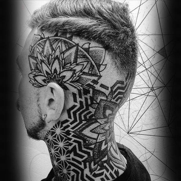 a man's head with an intricate tattoo on the side of his face and neck