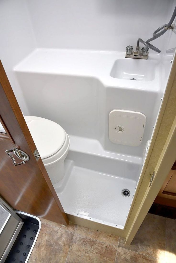 a white toilet sitting next to a bath tub in a bathroom on top of a tiled floor