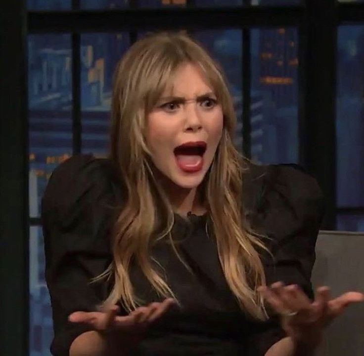 a woman with her mouth wide open on the tonight show, holding out her hands in front of her face